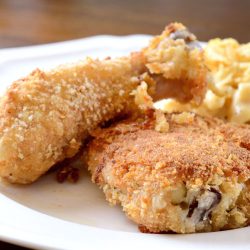 Plate of oven fried chicken with macaroni and cheese.