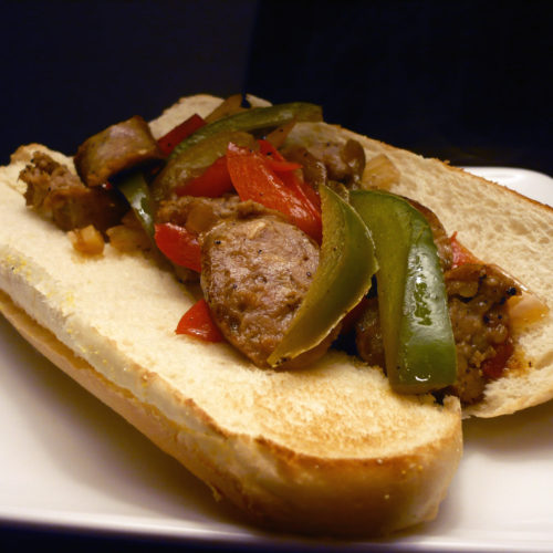 Sausage with peppers and onions on toasted roll.