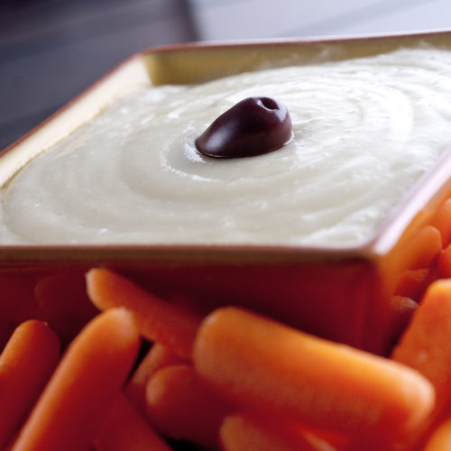 Greek skordalia in a square bowl with carrots.