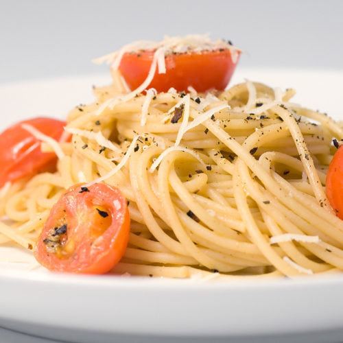 Plate of spaghetti with pecorino and tomatoes.
