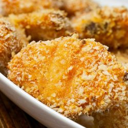 close up of sriracha chicken nuggets on white plate.