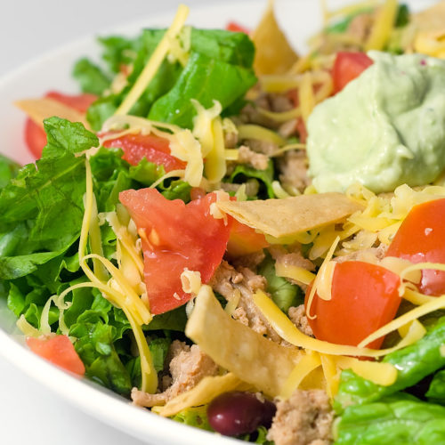 Taco salad in a white bowl.