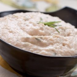 white bean and rosemary hummus in black bowl.