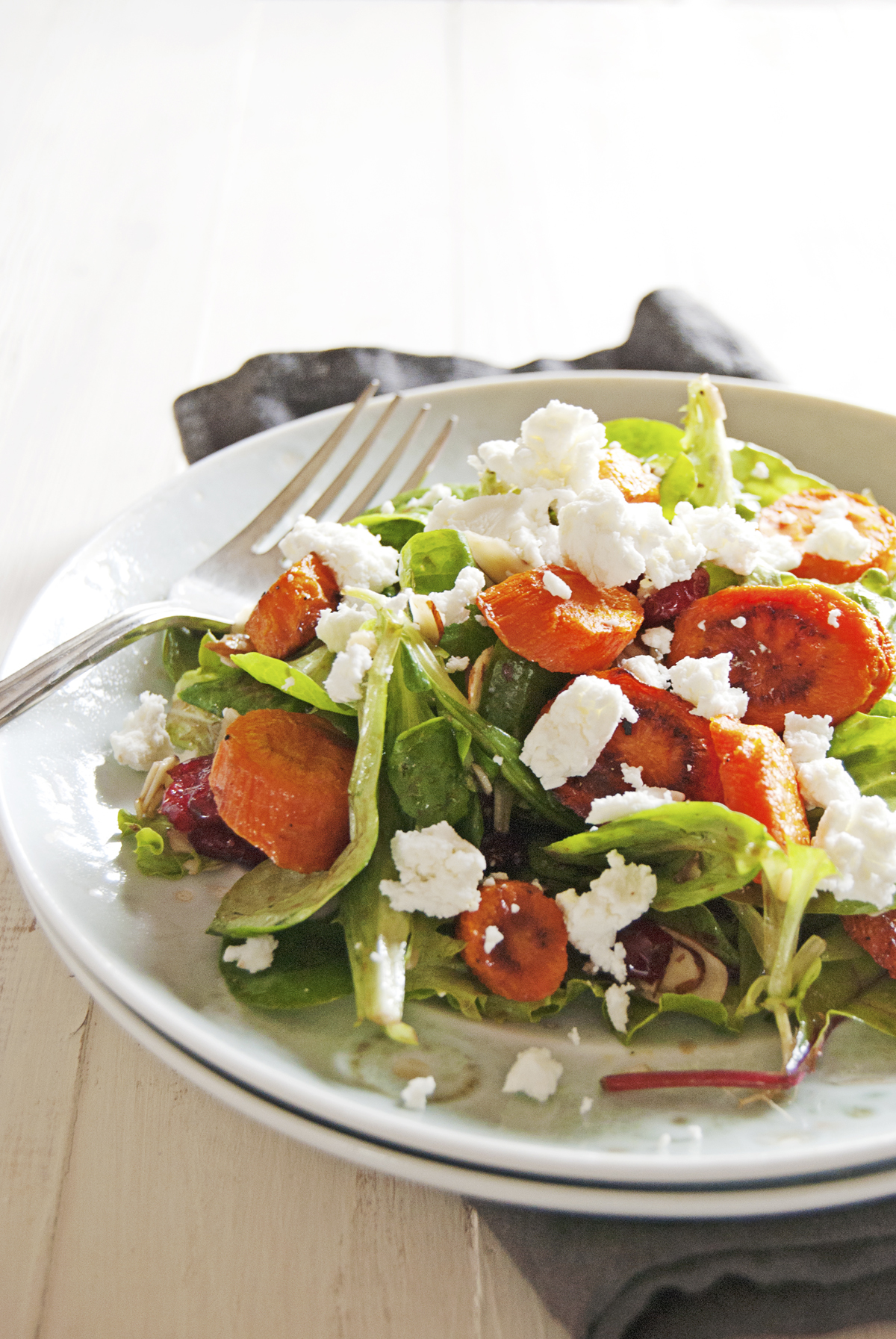 Say hello to the fall with this roasted carrot salad, featuring a balsamic vinaigrette, greens, and crumbled goat cheese.