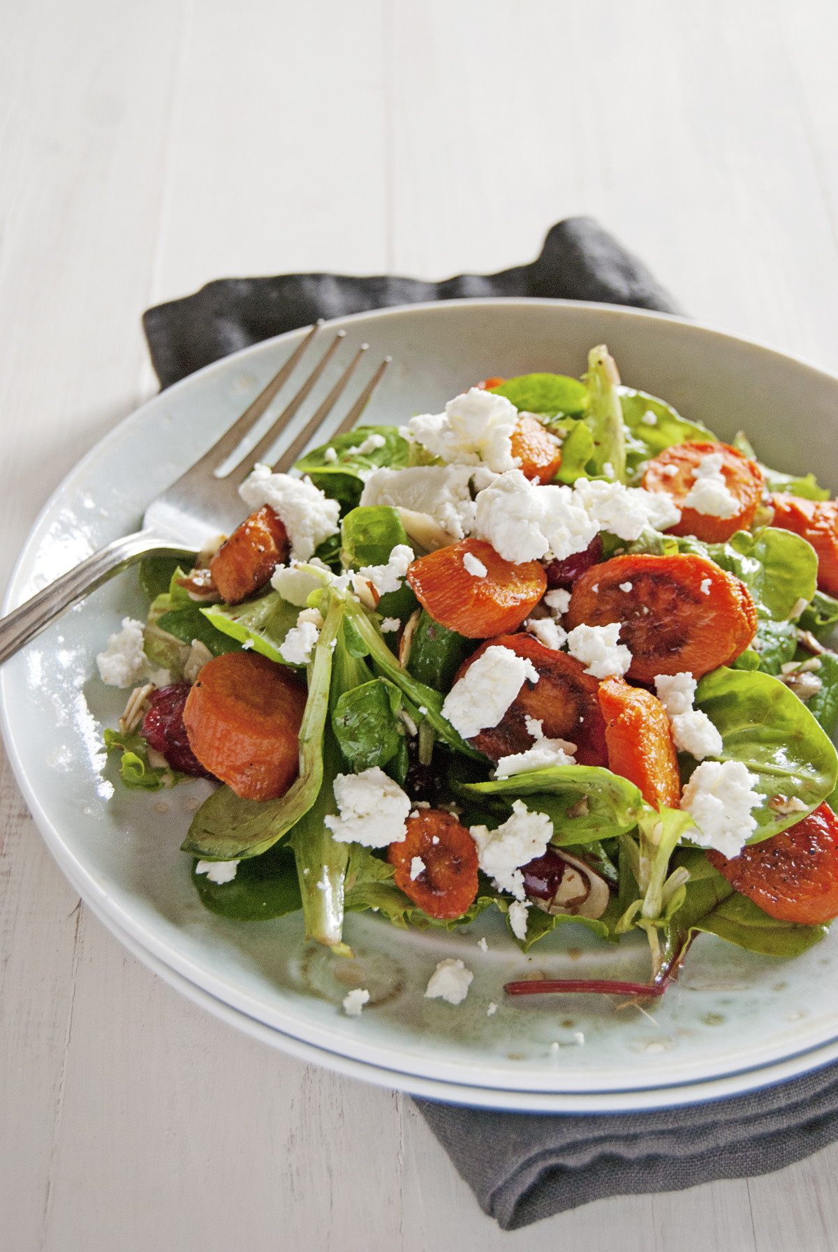 Say hello to the fall with this roasted carrot salad, featuring a balsamic vinaigrette, greens, and crumbled goat cheese.