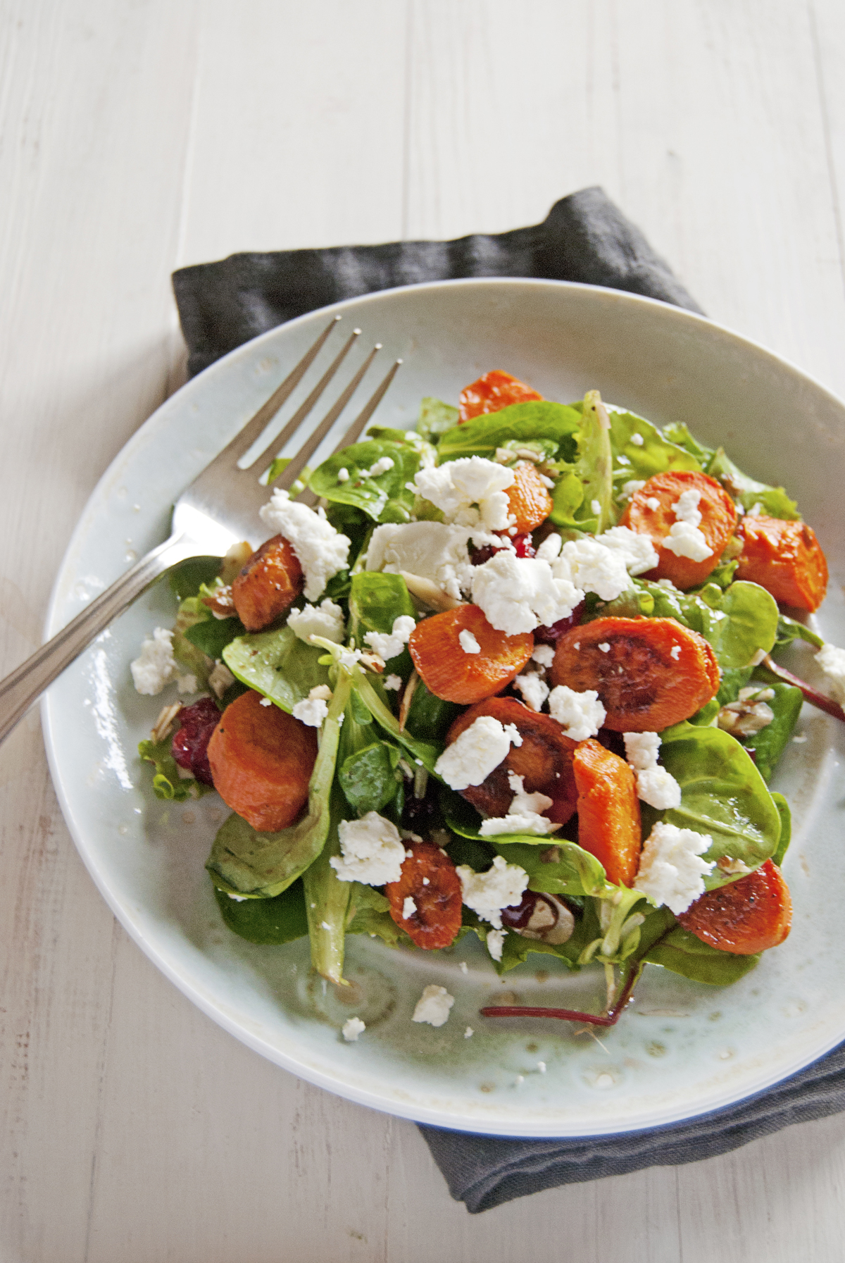 Say hello to the fall with this roasted carrot salad, featuring a balsamic vinaigrette, greens, and crumbled goat cheese.