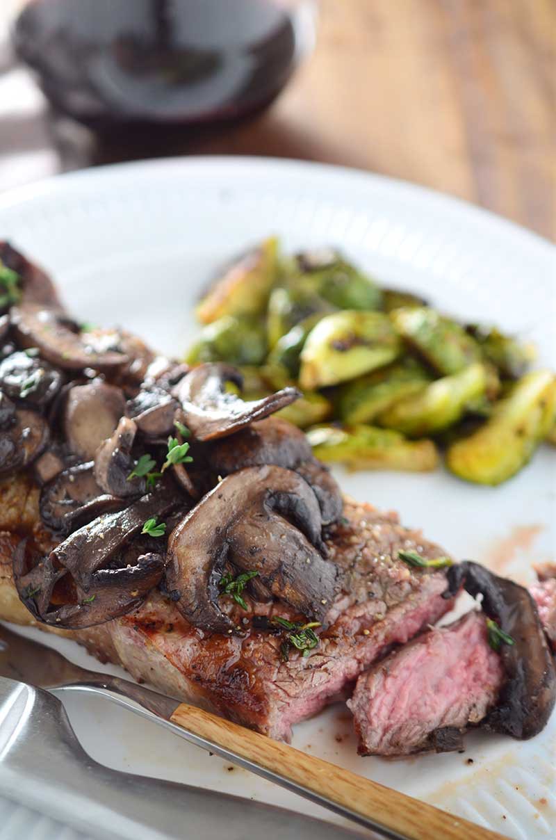 Perfectly grilled New York Strip steak smothered with red wine mushrooms.