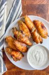 Overhead shot of beer brined chicken wings on white plate.