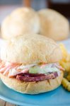Ultimate Corned Beef Sandwiches topped with melted Swiss cheese and a creamy horseradish slaw.