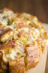  Pulled Pork Pull Apart Bread is loaded with succulent delicious pulled pork, cheese, chiles and onions. It’s the perfect cheesy snack for game day!