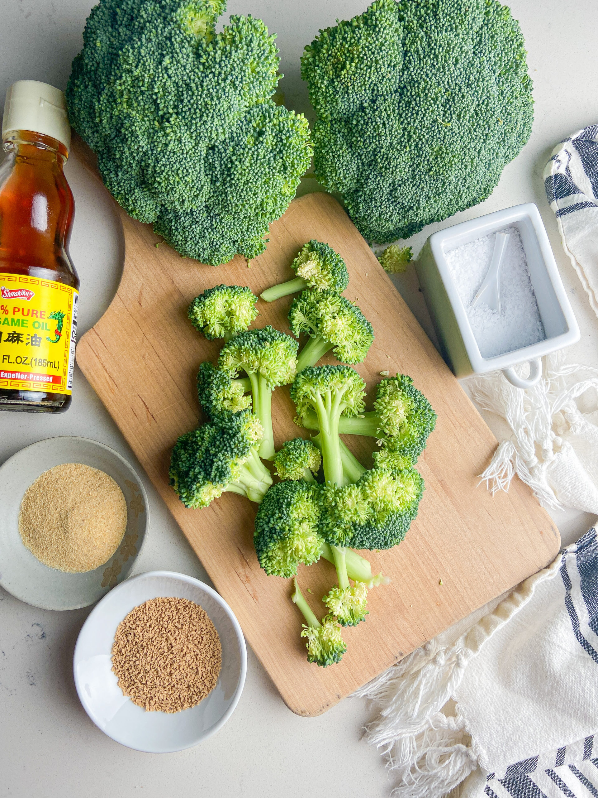 Overhead photo of ingredients needed for air fryer broccoli on a cutting board. 