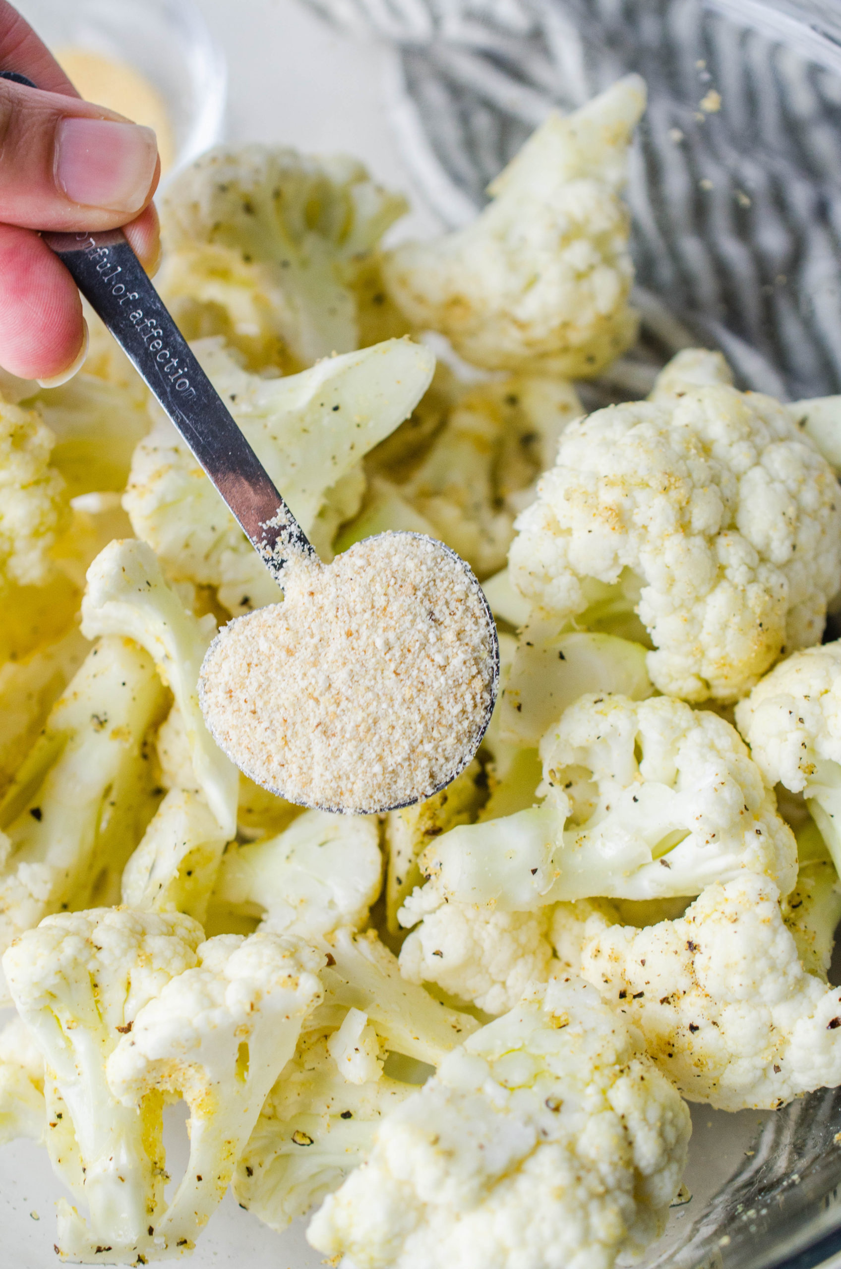 A spoonful of granulated garlic sprinkled over raw cauliflower