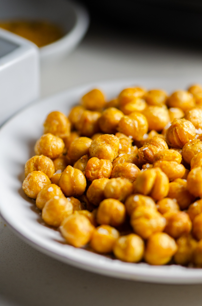 Close up side view of air fryer chickpeas on a white plate. 