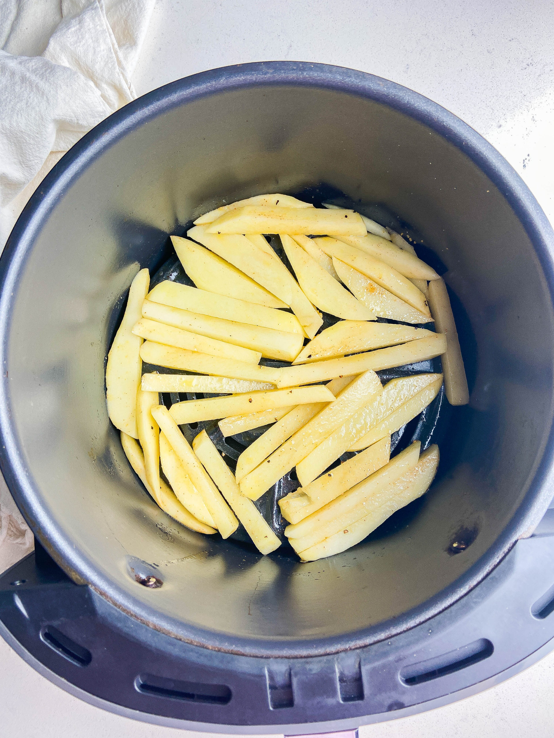French fries in an air fryer basket. 