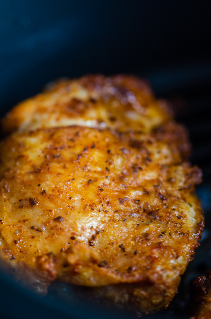 Close up of air fried chicken thigh in air fryer. 