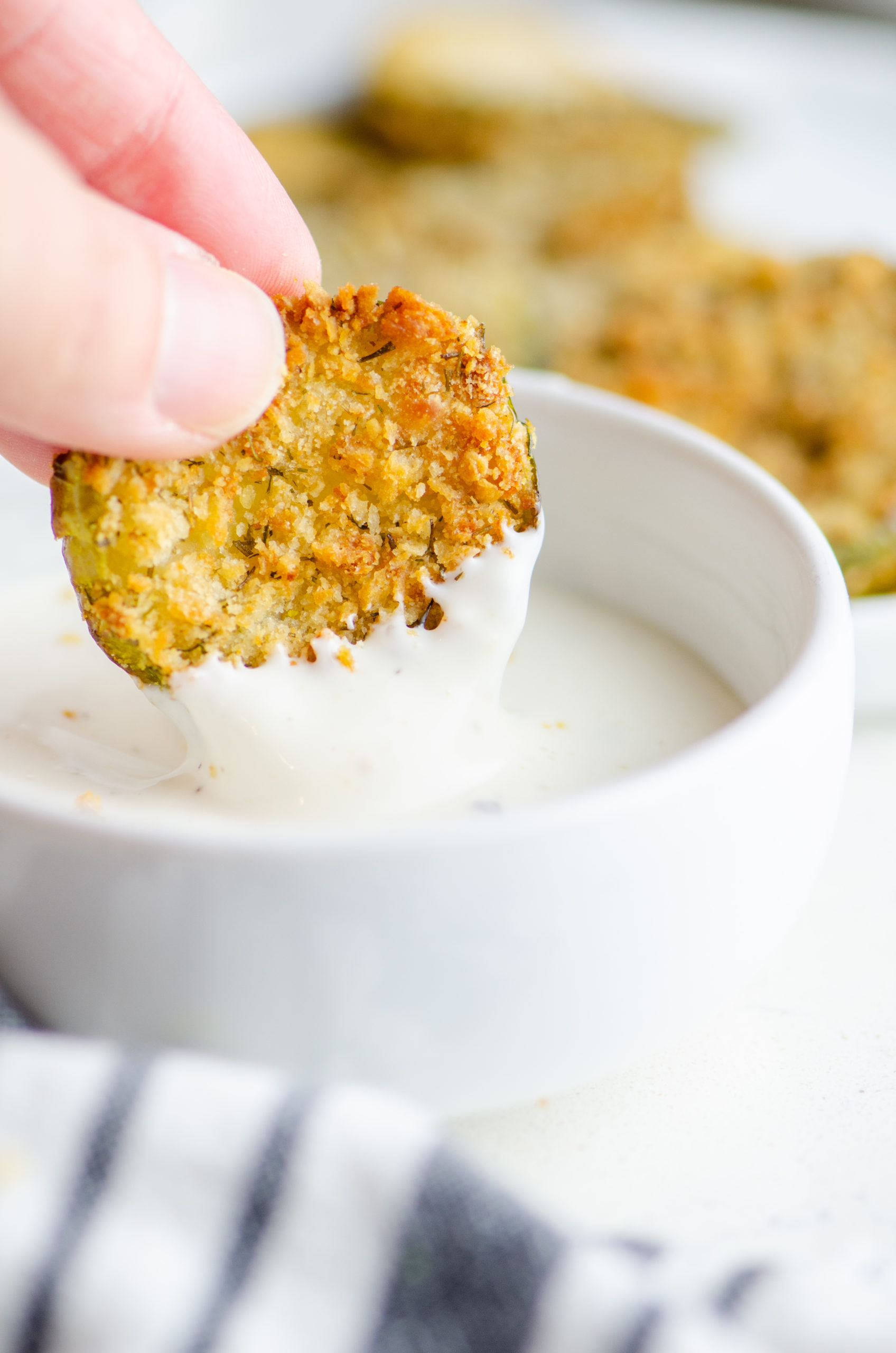 Dipping an air fried pickle in ranch dip. 