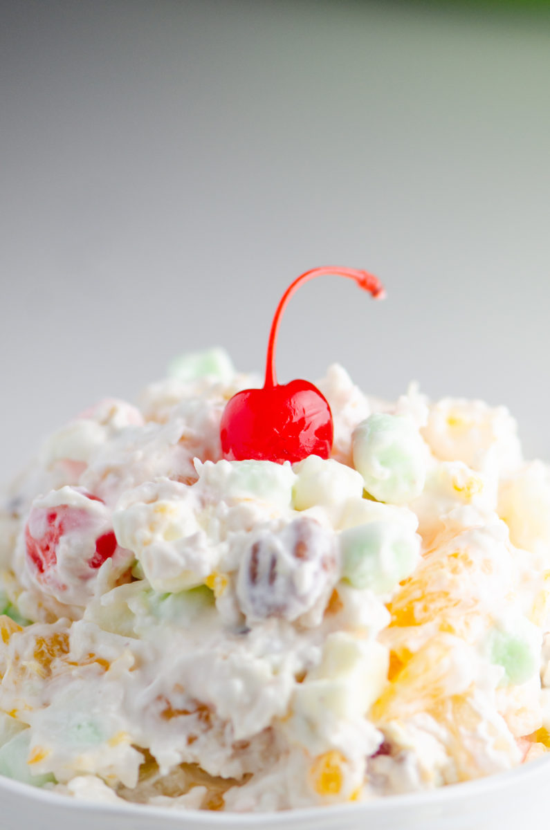Close up of ambrosia salad with cherry on top. 