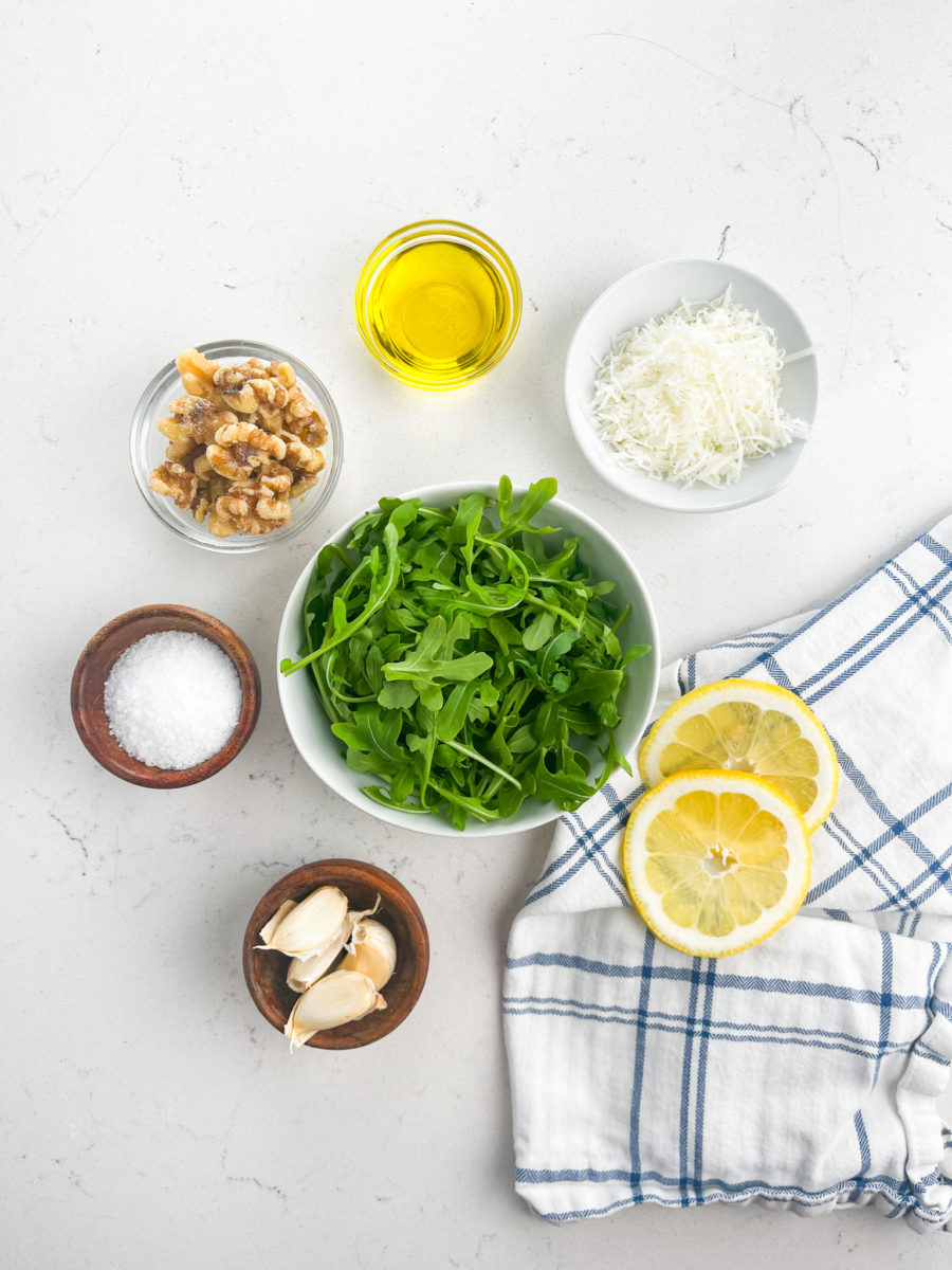 Ingredients for arugula pesto on a white background. 