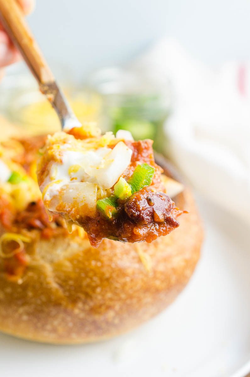 Spoonful of chili in a bread bowl. 