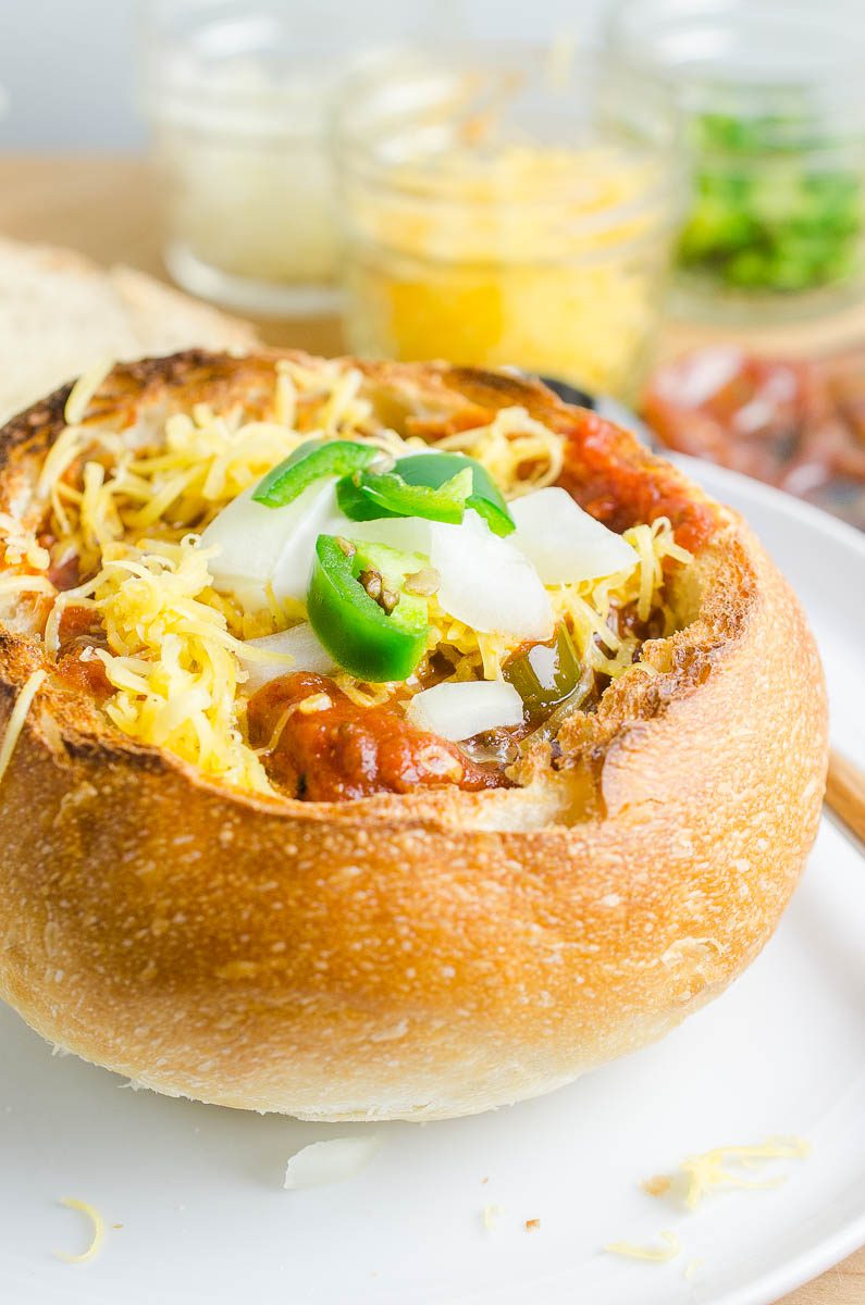 Chili in a bread bowl topped with cheese and jalapeno. 
