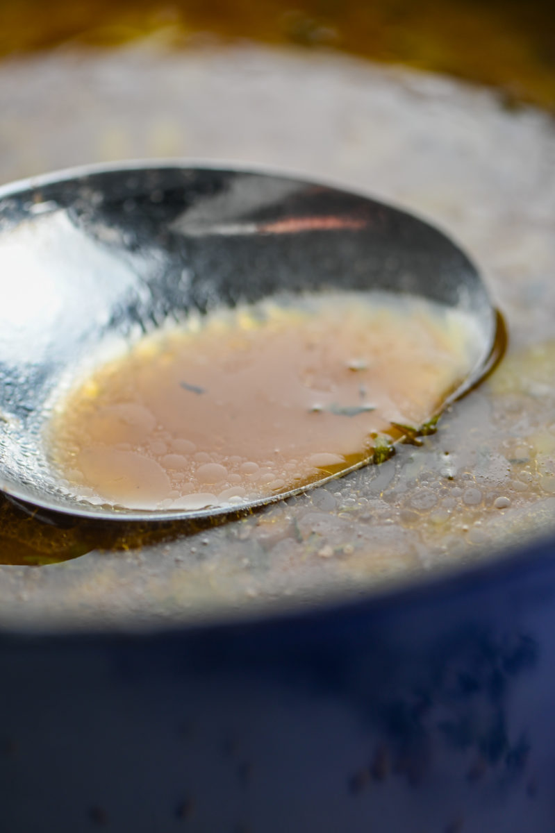 Skimming foam off top of soup. 