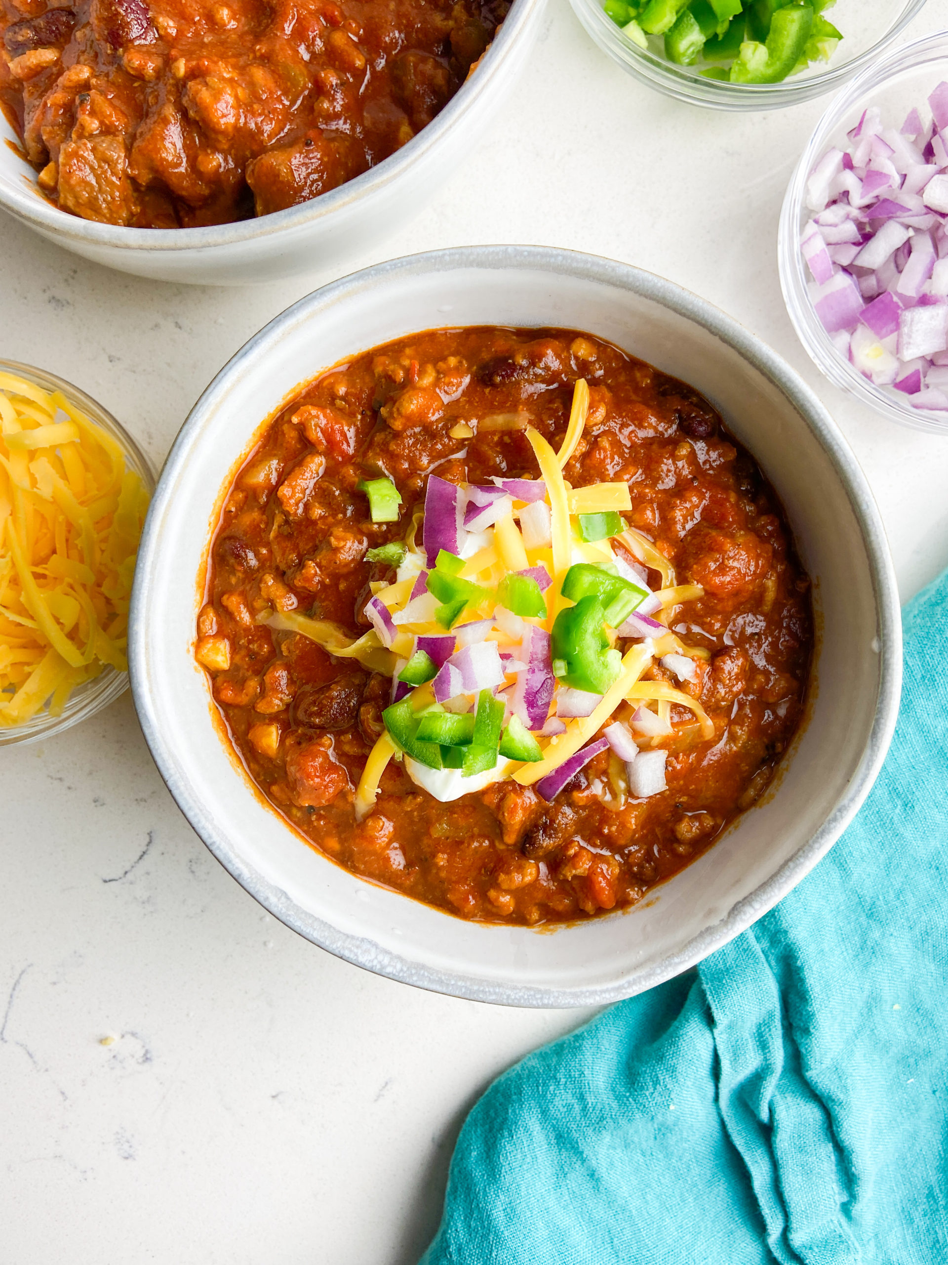 Overhead photo of chili in a bowl with toppings. 