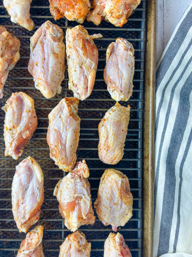 Chicken wings on top of cooling rack on baking sheet. 