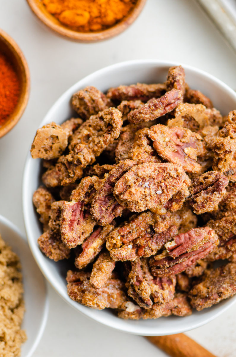 Candied pecans in white bowl.