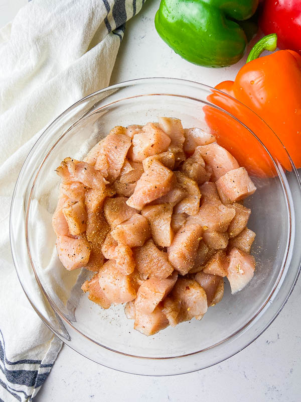 diced chicken coated in jerk seasoning in a clear bowl. 