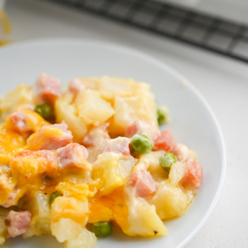 Ham potato casserole on white plate.