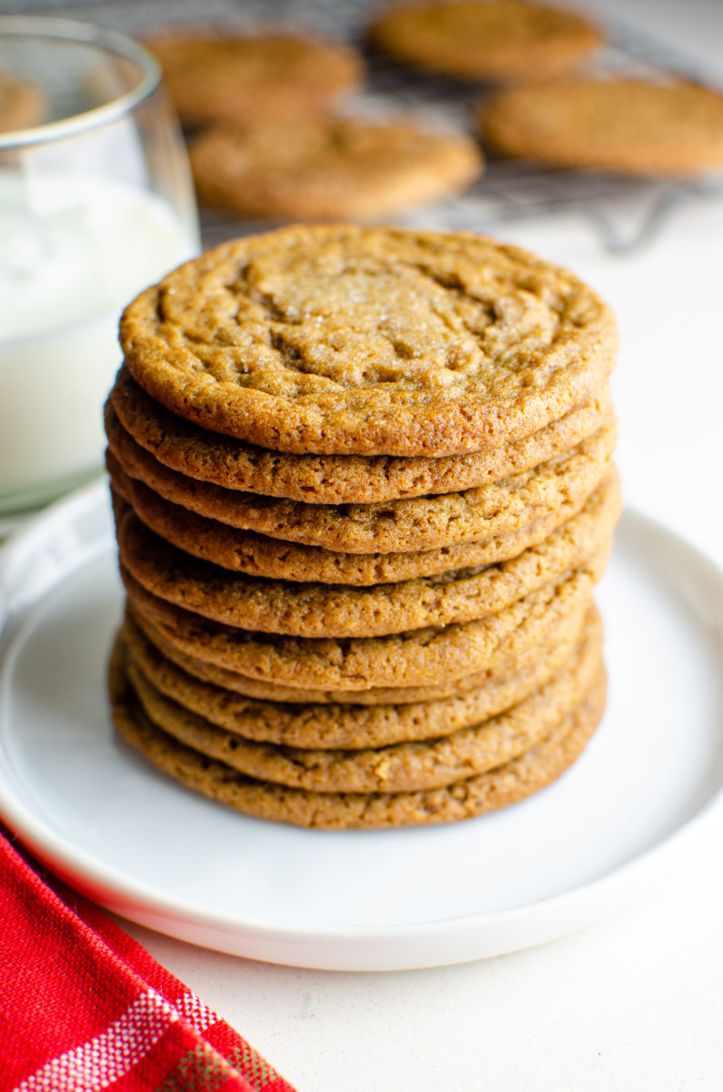 Stack of chewy molasses cookies on a white plate.