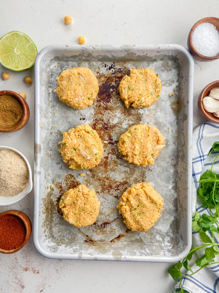 Chickpea cakes on baking sheet. 