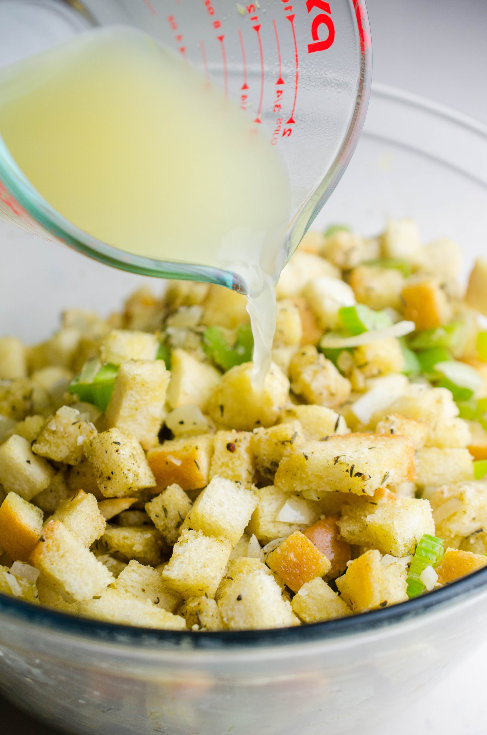 pouring chicken broth over stuffing. 