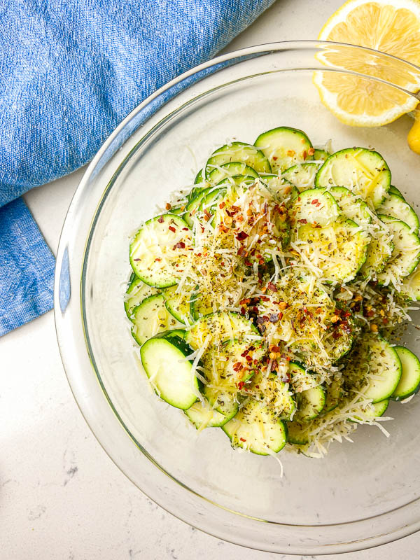 Ingredients for cold zucchini salad in a glass bowl. 