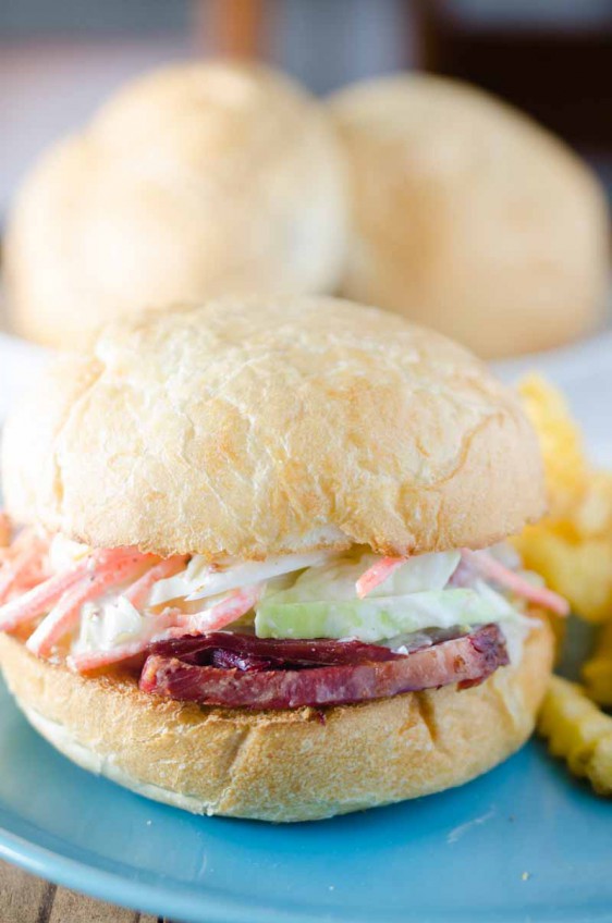 Ultimate Corned Beef Sandwiches topped with melted Swiss cheese and a creamy horseradish slaw.