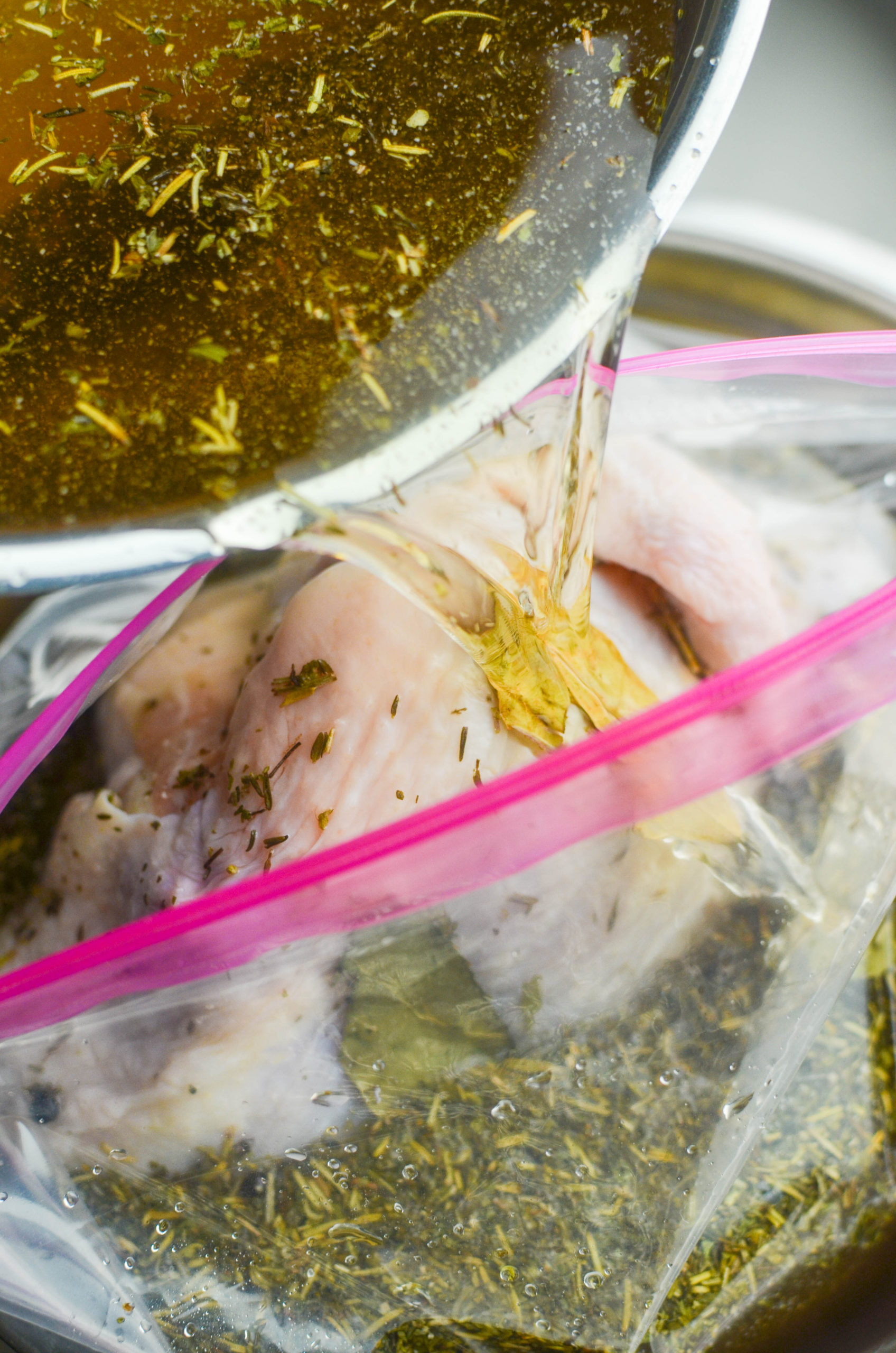 Pouring brine over chicken. 