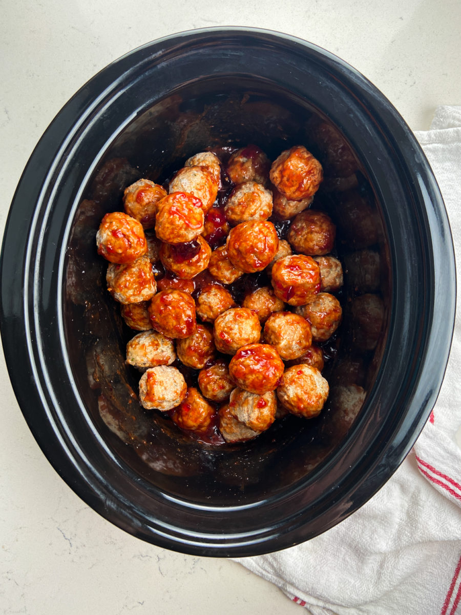 overhead photo of grape jelly meatballs in slow cooker. 