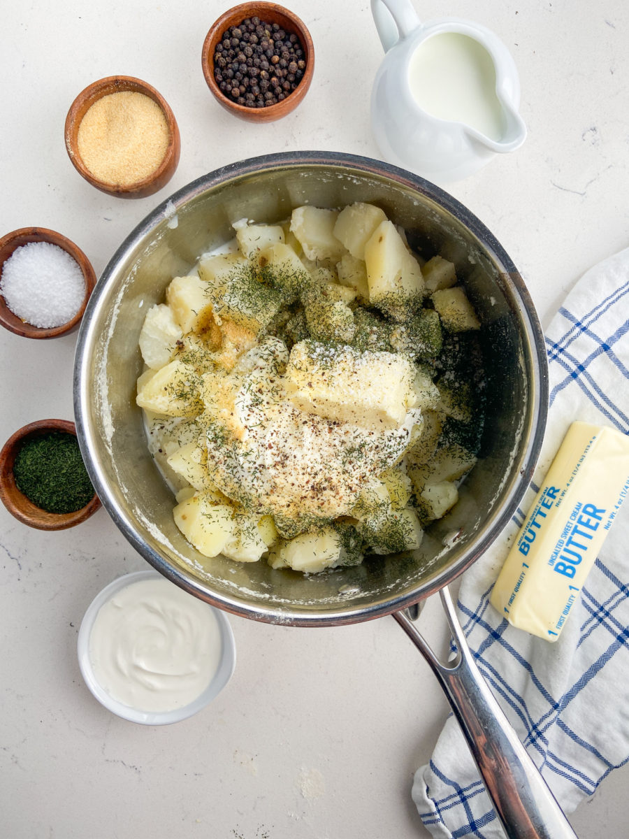 Cooked potatoes in pan with seasonings. 