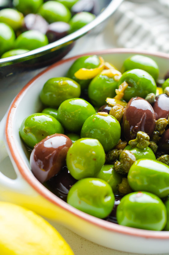 Side photo of warm marinated olives in a white dish