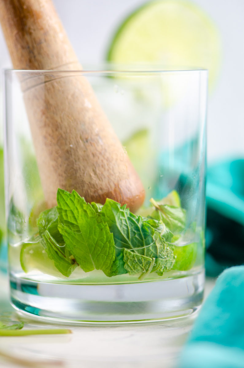 Muddling fruit in a glass to make a mojito. 