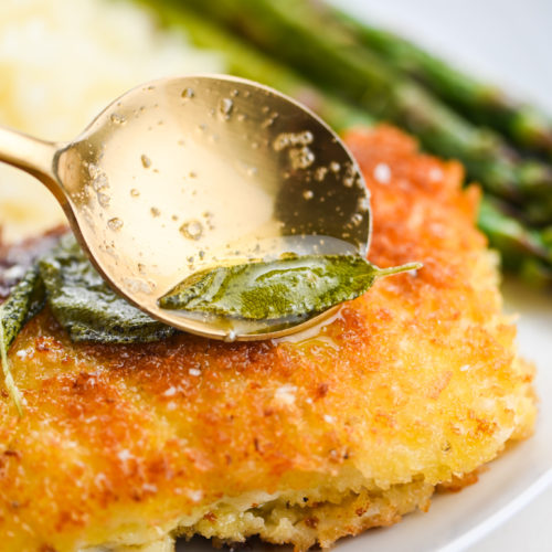 Drizzling sage butter sauce over fried cod.