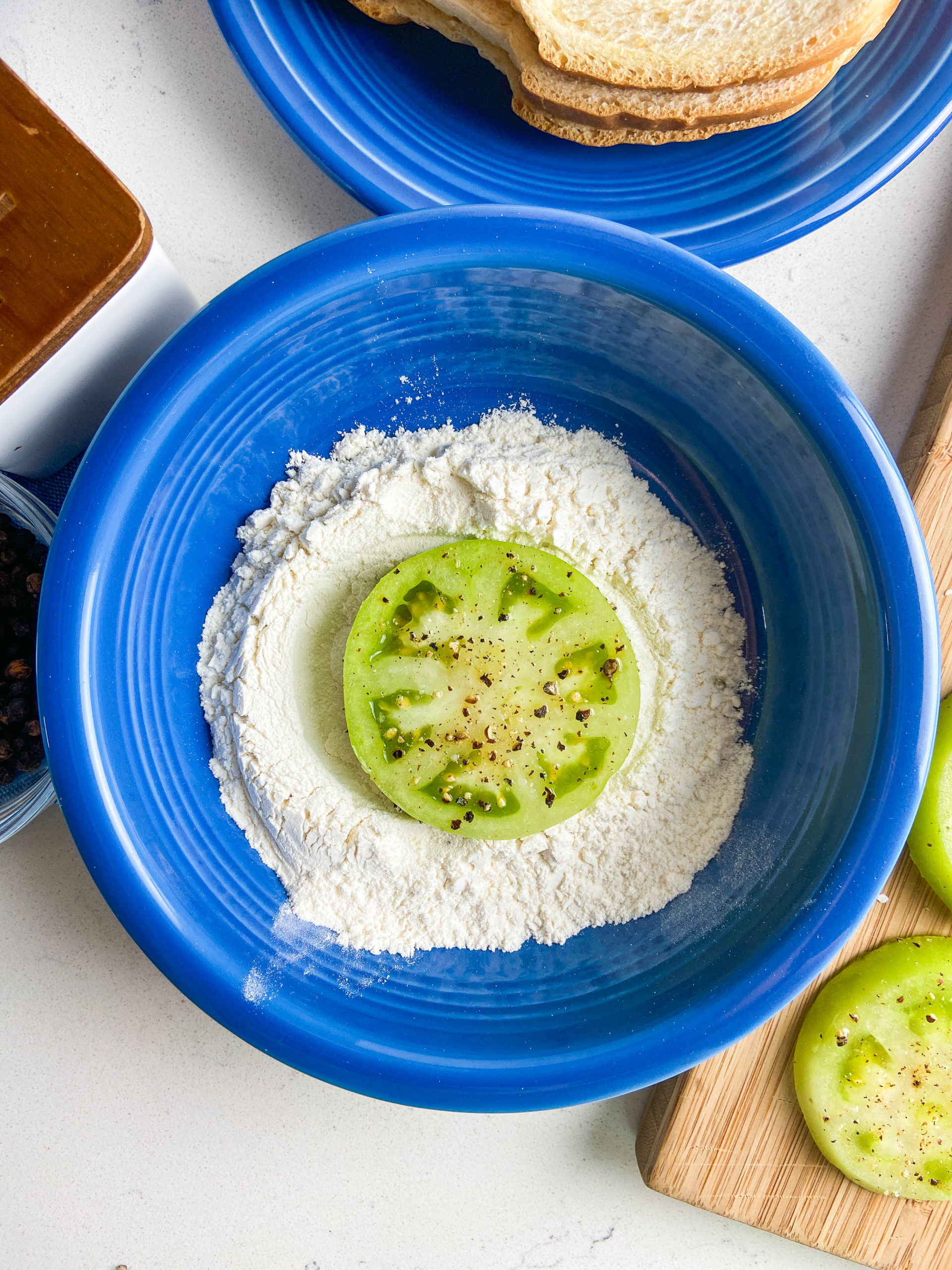 Green tomato in flour in blue bowl. 