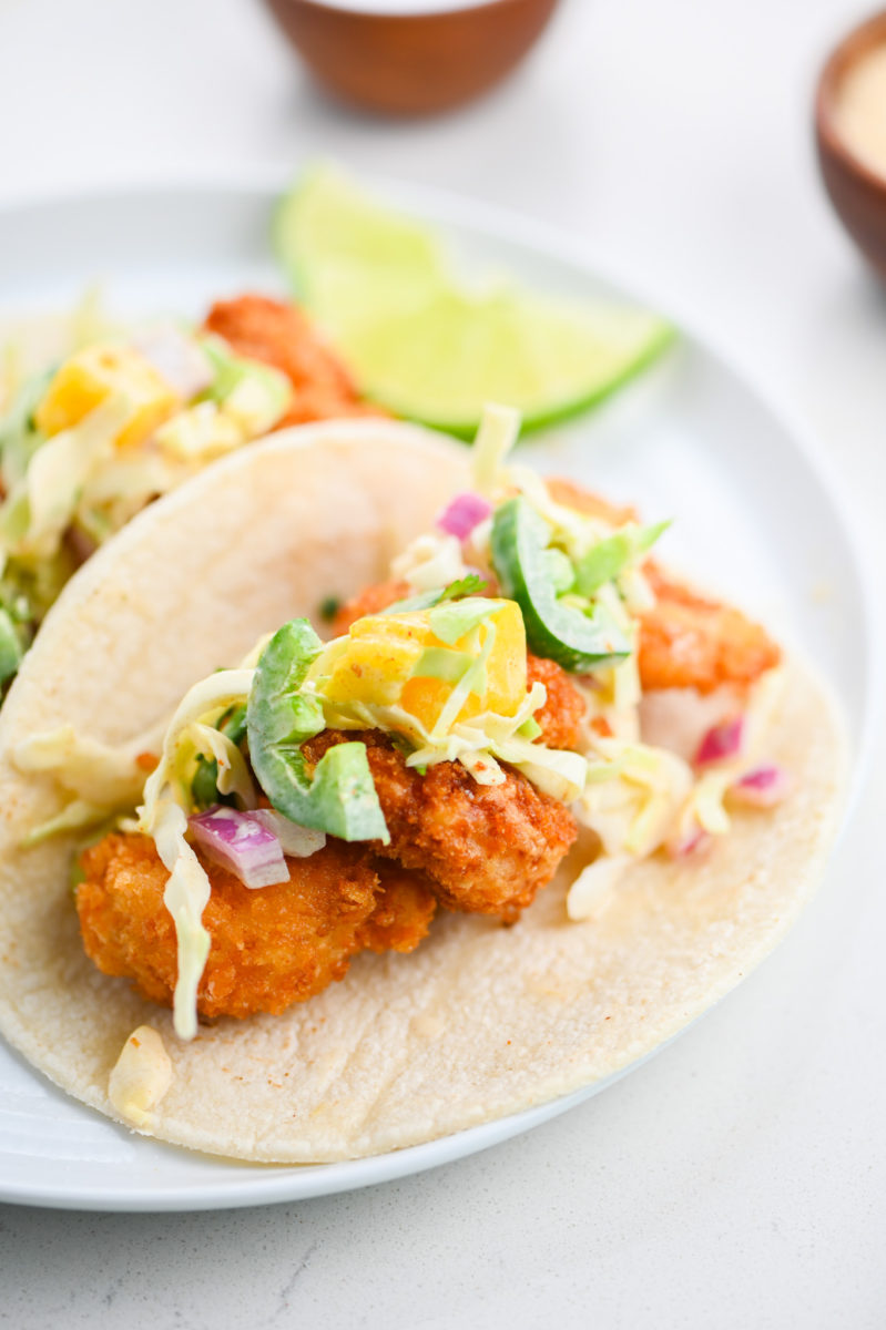 Fried shrimp tacos on plate. 