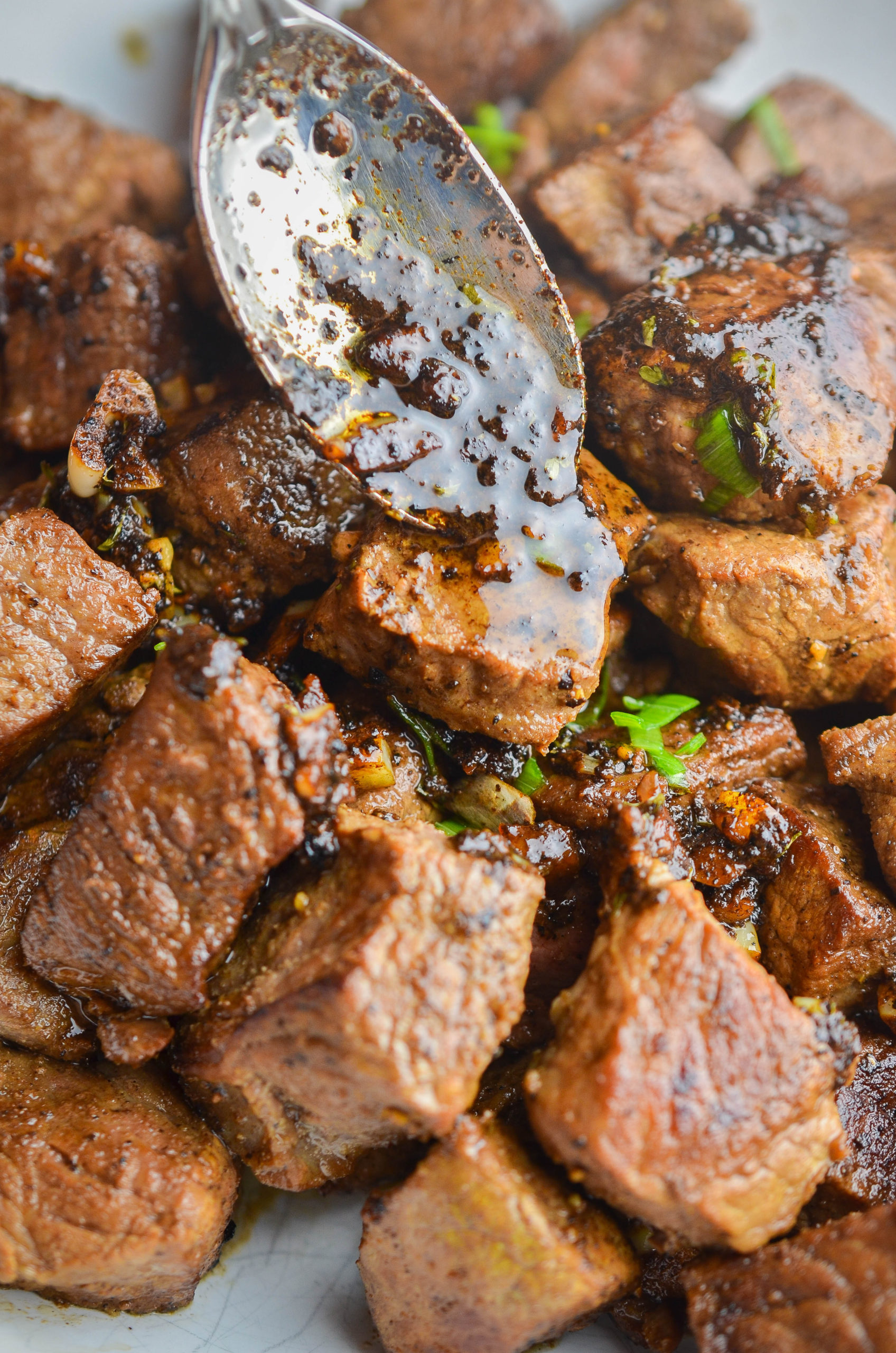 Spooning butter over steak bites. 