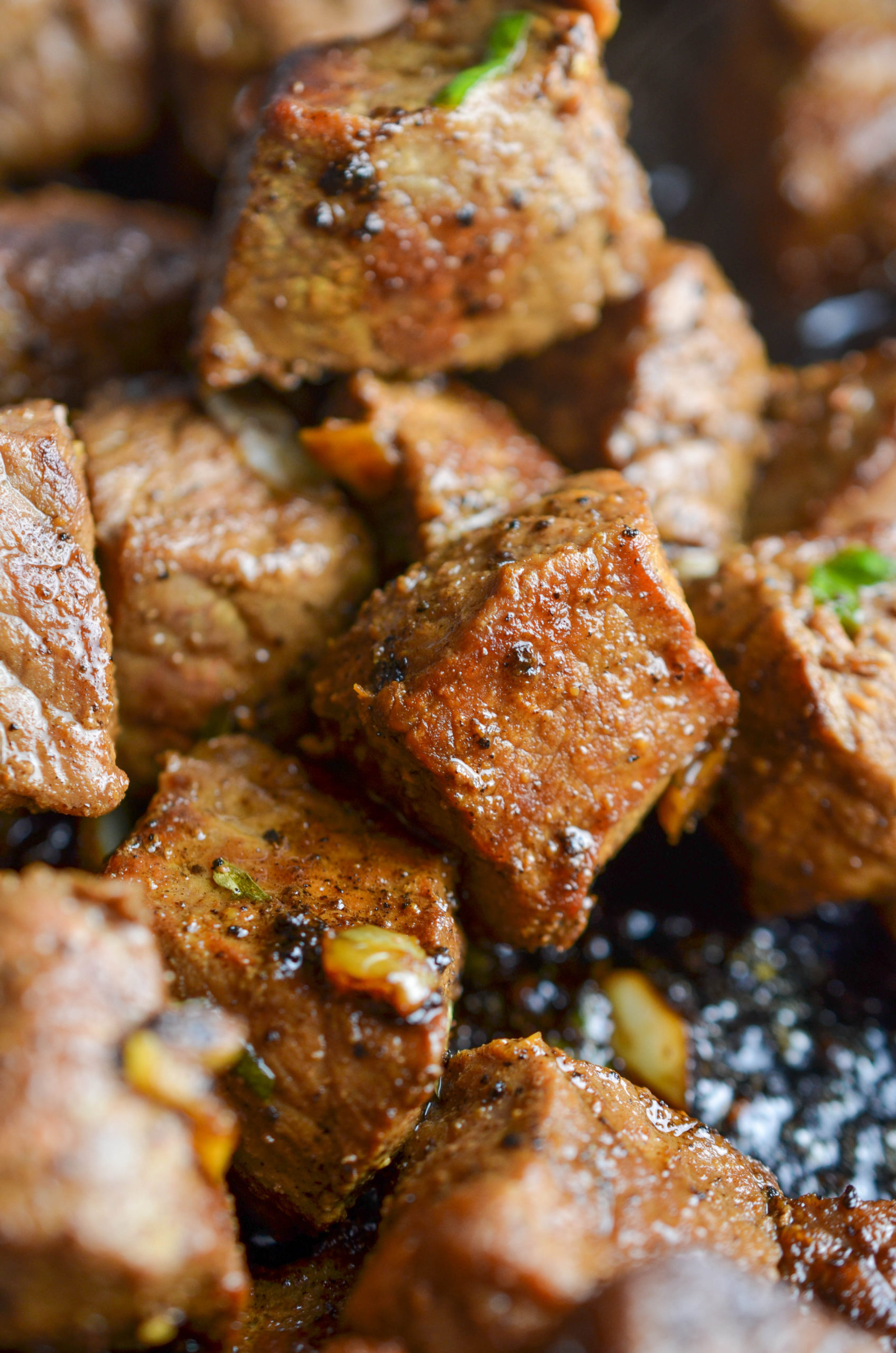 Side angle photo of garlic steak bite in a skillet. 