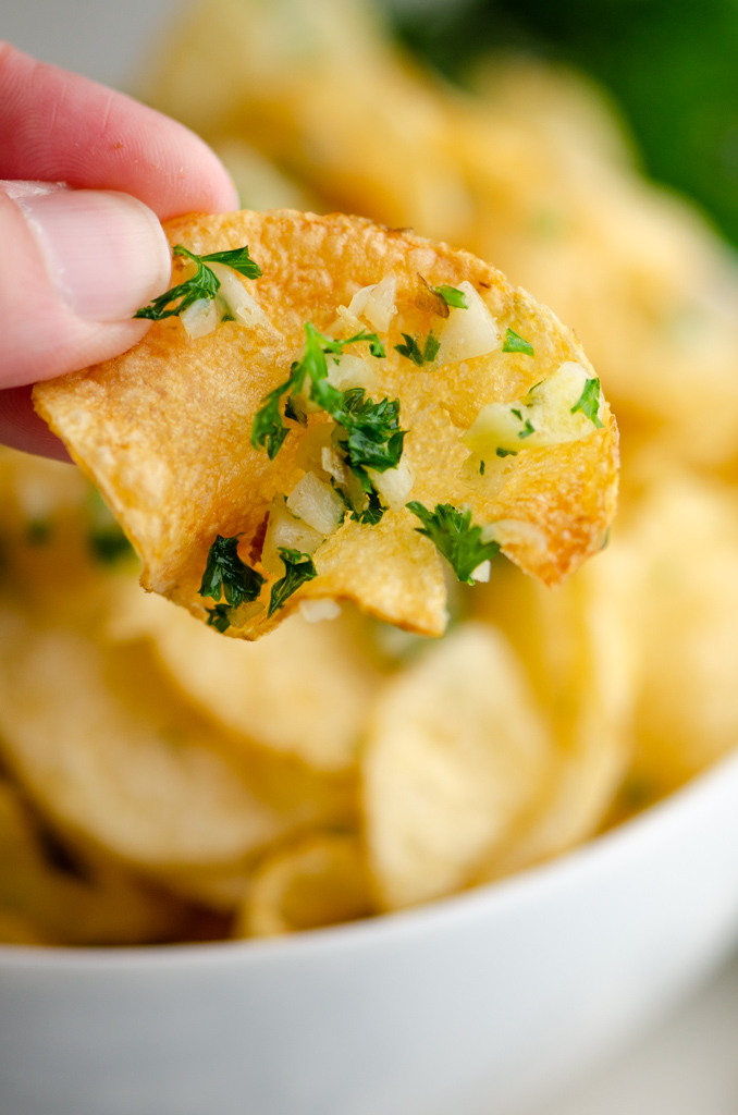 Hand holding single garlic chip 