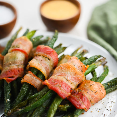 Green bean bundles on white plate.