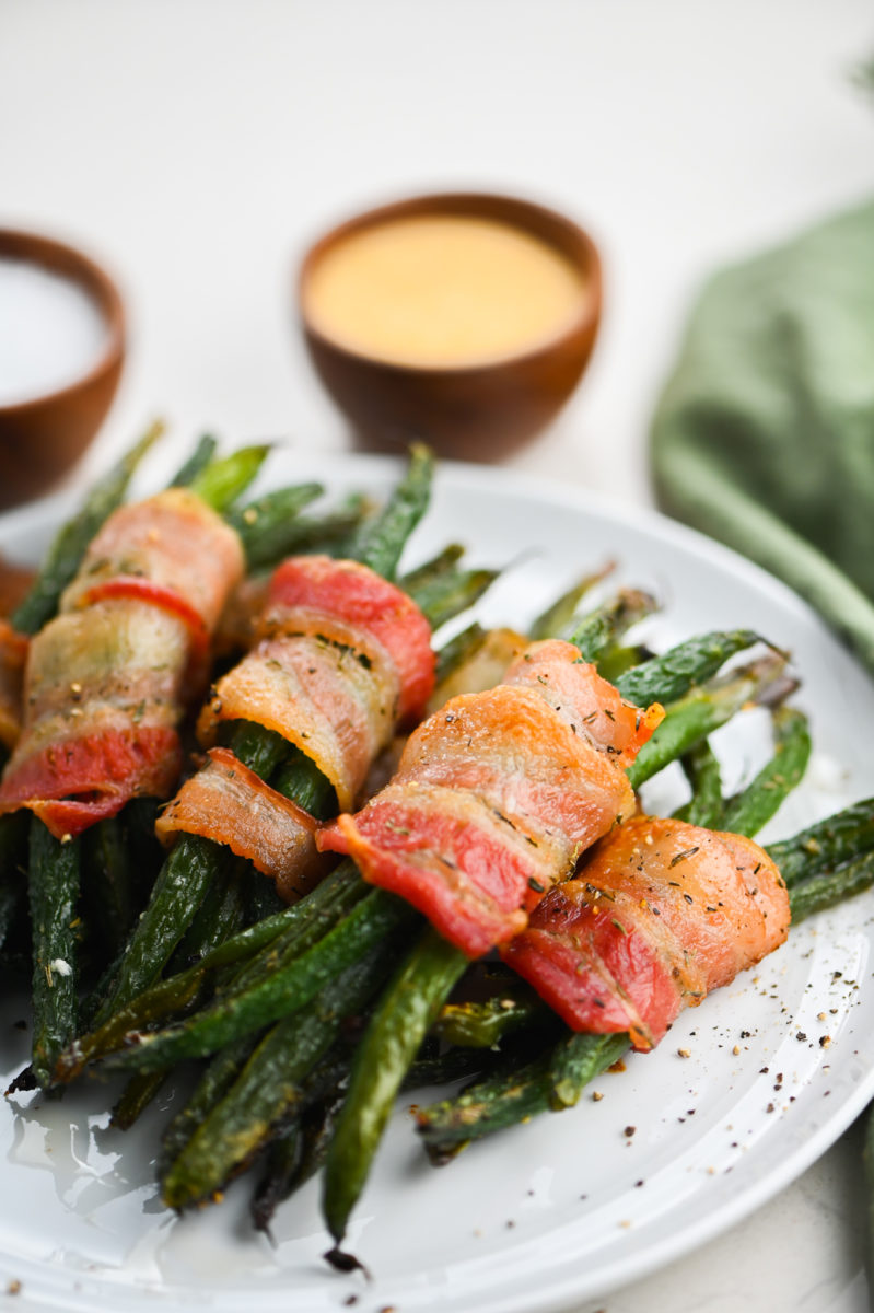 Green bean bundles on white plate.