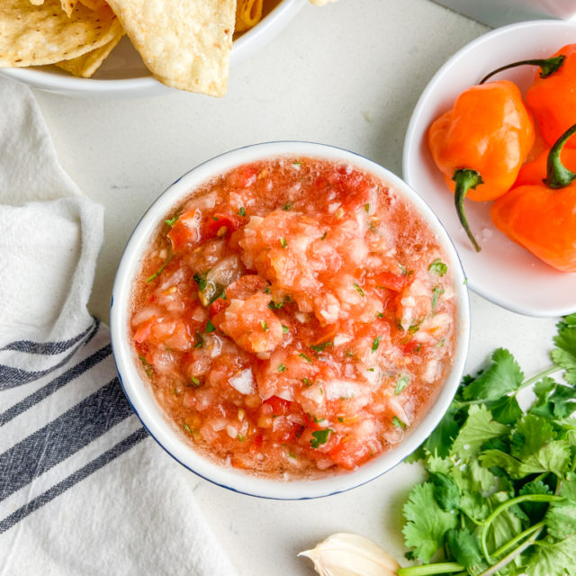 Overhead photo of habanero salsa with peppers and chips.