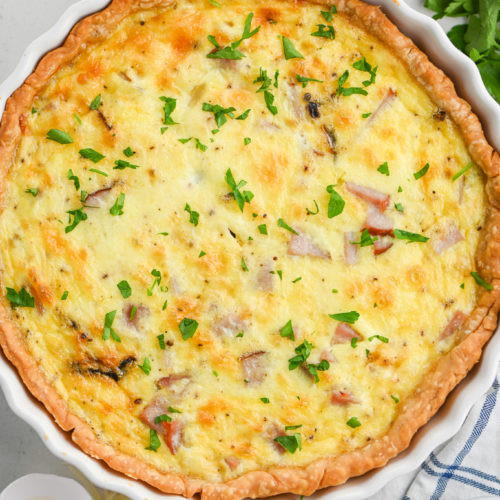 Ham and Cheese Quiche in white pie dish.